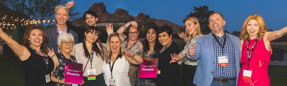 A group of people at the Spectrum Awards holding up their hands and celebrating outside in the early evening.